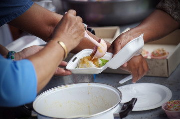 Rich people give food to the poor. starvation concept