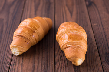 Two croissants on wooden table, Closeup