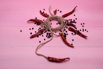 The circle hemp string,plenty of dried pepper around,put on pink pastel timber board,blurry light around.