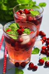 Close-up of a cranberry drink with ice and mint leaves. Selective focus