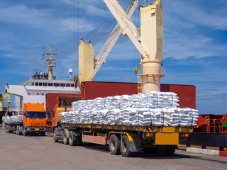 Sugar bags are loading in hold of bulk-vessel at industrial port,Pick up sugar bags from truck to ...