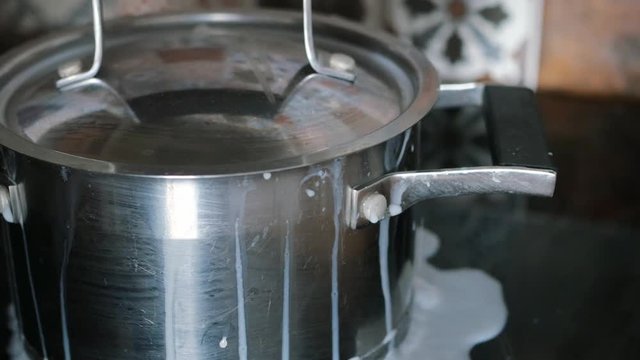milk, soup is boiling over, flowing out of the pot