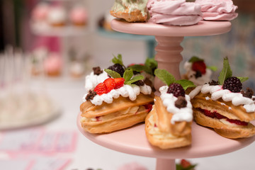 Eclairs with cream and fruit on the children's table