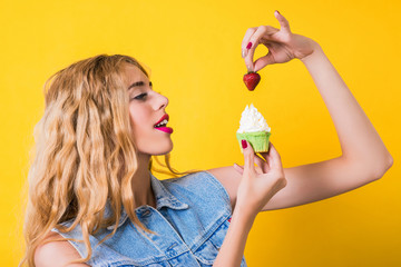 Stylish girl enjoying cupcake with strawberry.