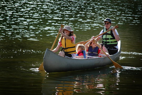Family Canoeing Together On Lake in Wilderness