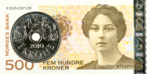 1 norwegian krone coin against 500 norwegian krone banknote