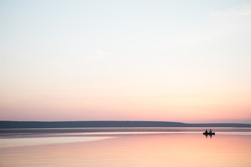Couple in a boat in a lake or pond or river in a sunset calm water no wind summer minimalism silhouette people beautiful meditation tourism outdoor meditation life happiness - 209367427