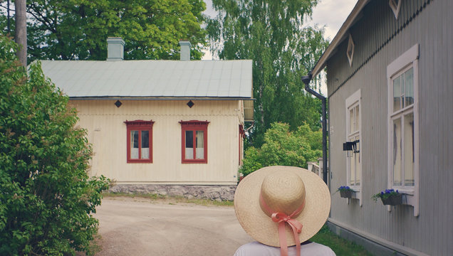 Girl Wearing A Summerhat Walking In A Smalltown In Summer