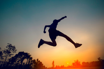 man jumping sunset background