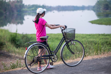 Obraz premium Young woman on bike on road