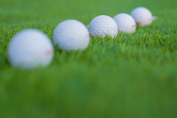Five golf ball on grass.