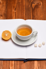 Hot beverage with sugar cubes placed on open book