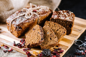Sweet rye bread with different ingredients on black wooden background