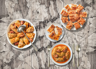 Traditional pickled Cabbage rolls served with Crumpled cheese pie on old rustic weathered cracked flaky garden table