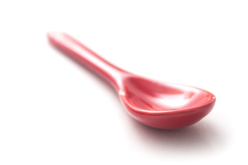 closeup of red spoon on white background