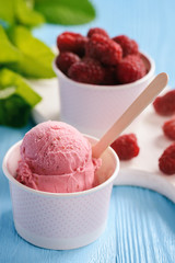 Vanilla and raspberry ice-cream on blue wooden background.