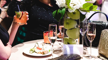 people are resting at a banquet. girl holding a glass of drink in her hand
