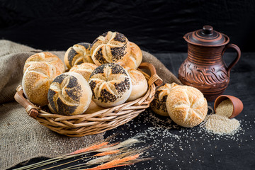 Sweet tasty buns in the basket on black wooden baclground