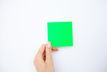 Office Hand Holding a Green Color Sticker on White Background. Copyspace. Place for Text.