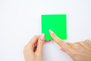 Office Hand Holding a Green Color Sticker on White Background. Copyspace. Place for Text.