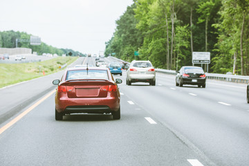 Commuter economy car driving down road, rear view