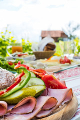 Brettljause, cold plate with meal on wooden table in vineyard