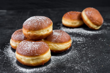 Sugar donat with fruit filling on black background