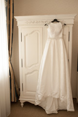 Wedding dress hanging on the cupboard