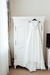 Wedding dress hanging on the cupboard