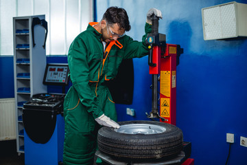 Mechanic removes car tire Machine for removing rubber from