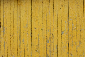 Old planks with shabby dried yellow paint. Close-up. Background. Texture.