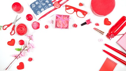 Women's things on a white table - a hairbrush, cosmetics, nail polish, candles and hearts.