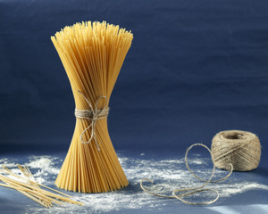 Uncooked pasta spaghetti on a purple background