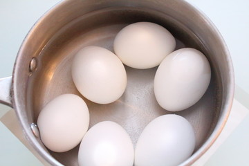White boiled eggs in a pot of water. Close-up.