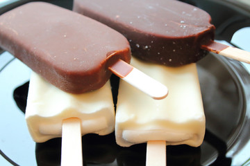 Creamy ice cream on a stick in chocolate glaze and white glaze. Eskimo. Close-up. Background.