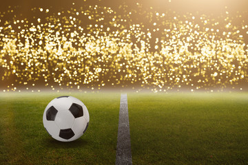 Fußball im Stadion vor hellen goldenen Lichtern