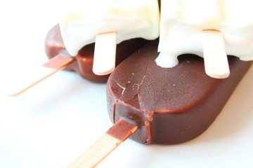 Creamy ice cream on a stick in chocolate glaze and white glaze. Eskimo. Close-up. Background.