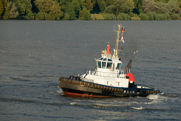Tugboat of red and white color in the river