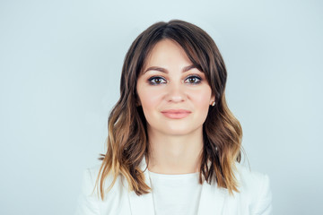 portrait of a beautiful and young woman chic makeup and hairstyle in white medical gown smiling on a white background