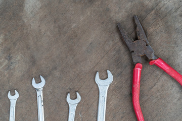 Wrench and .pliers on wood background