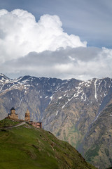 Naklejka premium Stepantsminda and Kazbegi's dramatic scenery and Gergeti Church, Georgia.