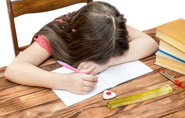 Girl tired and sleeping when doing his homework.