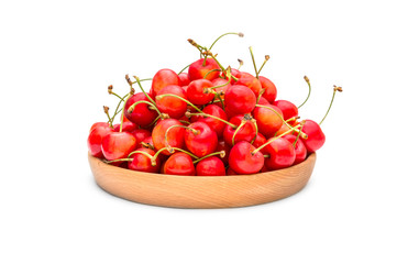 Wooden plate with cherries on white background.
