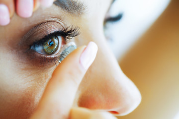 Health. Beautiful Young Girl Holds On A Finger Contact Lens. Portrait of a Beautiful Woman with...