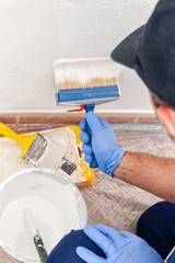 House painter at work painting a wall with a brush © francescomou