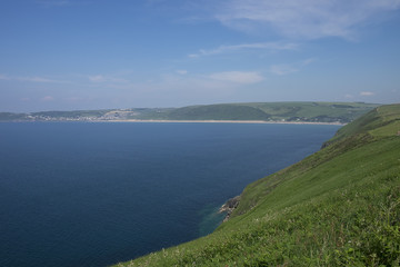 view of Puttsborough Sands and Woolacombe beach with the sea beyond and blue sky on a sunny day in the summer. North Devon, United Kingdom