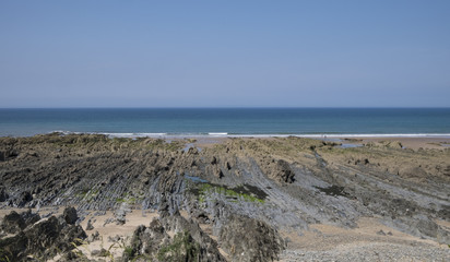 Fototapeta na wymiar View of rocky beach on a sunny day in the summer. North Devon, United Kingdom