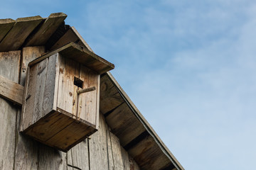 Fototapeta na wymiar Wooden birdhouse on a wooden barn wall