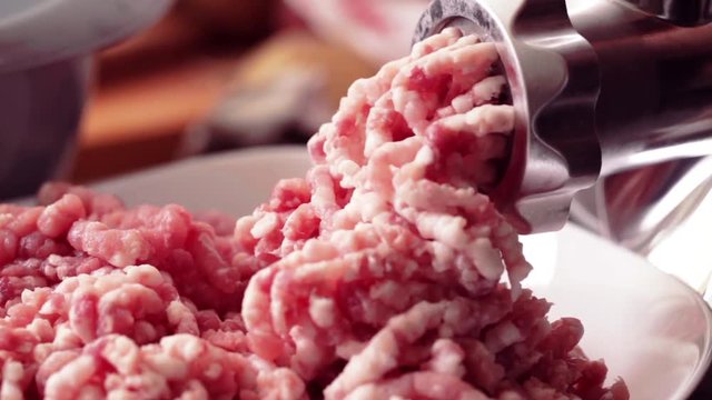 Meat grinder in action - fatty pork minced, close-up, no people