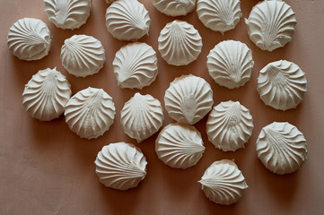 Lots of marshmallows on a cream background. Pastel image of sweetness. A lot of the texture